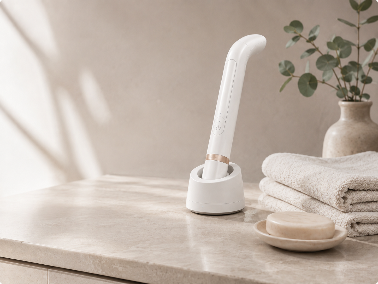 The VELLA dryer resting in its dock on a bathroom counter beside folded towels.